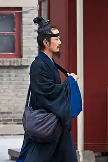 A Taoist man with a topknot and cross-collared robe.