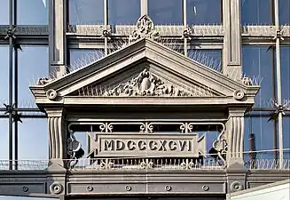 Neoclassical cartouches in and under a pediment of the Traian Hall (Calea Călărașilor no. 133), Bucharest, by Giulio Magno, 1896