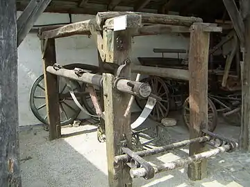 Ox shoeing sling in the Dorfmuseum of Mönchhof, Austria; a pair of ox shoes is attached to the near left column.