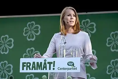 Annie Lööf speaking in front of a podium