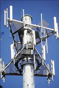 Sector antennas (white bars) on cell phone tower.  Collinear dipole arrays, radiating a flat, fan-shaped beam.