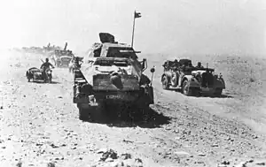 Armored vehicle convoy moving through a dessert