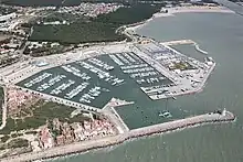 Aerial view of a typical marina (harbor dredge and lighthouse in lower right)