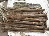 A hard-broom (walis-tingting) stall in the Philippines. Philippine hard brooms are often made from the hard primary veins of the leaves of the coconut palm frond.