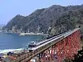 Taken from the mountain behind Amarube Station, a Hamakaze express service crosses the bridge