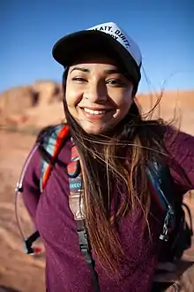 Ambreen Tariq poses in front of a desert landscape