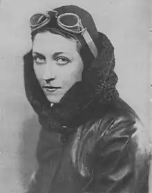 Black and white portrait photograph taken around 1930 of Amy Johnson, wearing aviator attire; googles, leather cap, leather and wool flying jacket