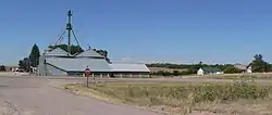 Grain bins, half a dozen houses; highway in foreground