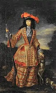 A lady wears a yellow and red riding dress against a cloudy-sky. She embraces a firearm with her right hand; and a dog with her left.