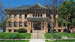 Two-story building on a raised basement with a central entry approached by stairs