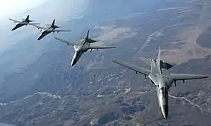 High front view of four swing-wing jet aircraft in flight