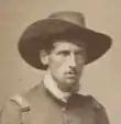 Old picture of a young-looking American Civil War officer wearing hat with mustache and low beard