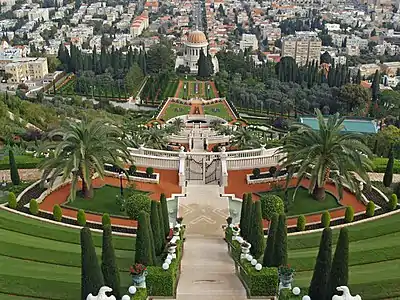 Elaborate gardens with several gates and a walkway leading to a domed building in the distance