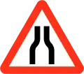 Road narrows on both sides