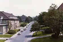 A photograph of a street and buildings inside Barker Barracks c1980. Taken from a high vantage point in the main HQ building it is looking eastwards.