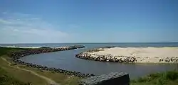 The mouth of Arroio Chuí on the Atlantic Ocean. Brazil on the left, Uruguay on the right.The stone breakwater on the left is both the southernmost and the westernmost point of the Brazilian coast; the one on the right is both the northernmost and the easternmost point of the Uruguayan coast.