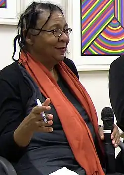 A portrait of bell hooks, black woman with glasses speaking