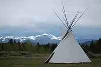 White teepee with mountains in background