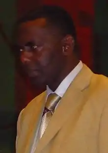 Cropped image of Biram Dah Abeid looking left, wearing a yellow suit, white shirt, and gold tie.