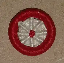 'Blandford Cartwheel' type of Dorset button, made in red and white yarn