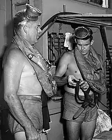 This is a photo of Commander George F. Bond and Chief Engineman Cyril Tuckfield after safely completing a 302-foot buoyant ascent in 52 seconds from the forward escape trunk of USS Archerfish bottomed at 322 feet.