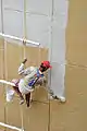 A painter working on an exterior wall in Kolkata, 2010