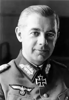 A man wearing a military uniform and neck order in the shape of a cross.