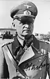 A man wearing a military uniform with an Iron Cross displayed at the front of his uniform collar.