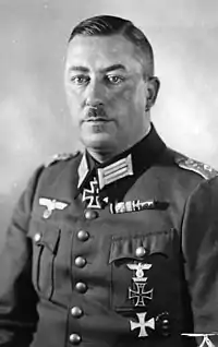 A man wearing a military uniform with an Iron Cross displayed at the front of his uniform collar.