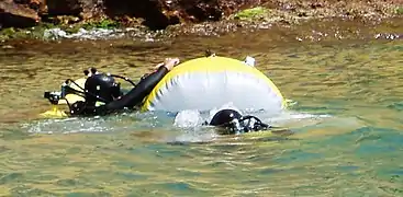 Divers on the surface with lift bags.