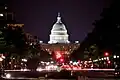 US Capitol Building lit up at night with the streets of Washington DC