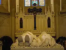 Tomb with effigies of Emperor Pedro II of Brazil and his wife Teresa Cristina in the Cathedral of Petrópolis, Brazil. An altar crucifix is seen in the background. The cross is made of black granite from Tijuca forest.