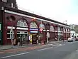 A red-bricked building with a blue sign reading "UNDERGROUND" in white letters such that the "U" and the "D" are larger than the rest of the letters