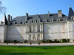 Large, two-story white building with gray slate roof