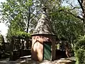 A garden folly with an overhead trellis around part of it