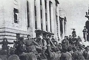 A group of soldiers dancing in front of a building