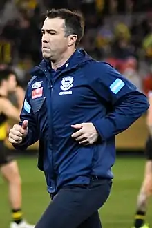 Male football coach jogging on playing surface