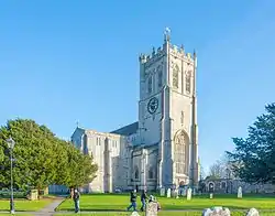 West end and tower of the priory against a bright blue sky