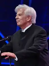 elderly man with full head of white hair in formal attire