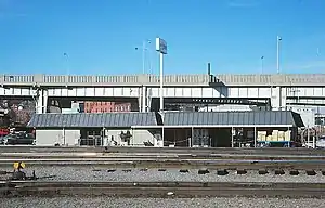 A train station with an elevated highway behind