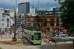 Tram 2540 near the ruins of the House of Reeves furniture store, four days after the building's destruction in the 2011 England Riots