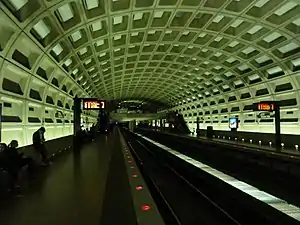 An underground metro station with two side platforms in an arched concrete vault