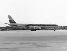 A black-and-white photograph of a Douglas DC-8 aircraft on the tarmac