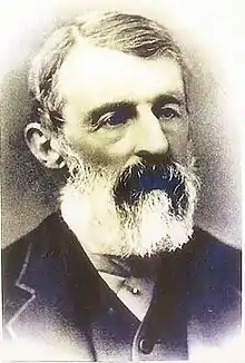 A black and white photograph of Daniel Lucius Adams with white beard and moustache, showing his head and part of the shoulders.