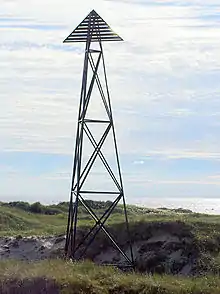 Dagmerke ved Jærens rev. Konstruksjon i rustfritt stål reist av grunneigarar, Klepp historielag og Jærens kystlag 25. August 2004. Høgd 16,5 meter, vekt meir enn 3 tonn. Merket har ein sidekant på fire meter. Første gong reist i 1854 (av tre), andre gong av stål i 1911 og tatt ned i 1994