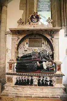 Monument to Sir Edward Denny and his wife at Waltham Abbey Church (1600). The kneeling figures in the frieze below depict his ten children and are known as "weepers". In the spandrels, allegorical figures of Fame and Time look on.