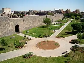 Photograph showing walkways in front of the walls of Amida with buildings in the background