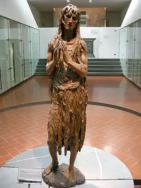 Wooden statuette of an elderly woman doing penance