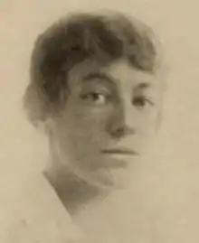 A young white woman with wavy hair, wearing a white blouse