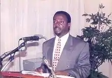 Man standing at a podium in front of microphones